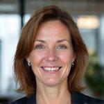 Portrait of Anna Meier, a smiling Swiss woman with professional attire.